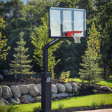 Dominator 72 inch adjustable basketball hoop with tempered glass backboard installed on a backyard court