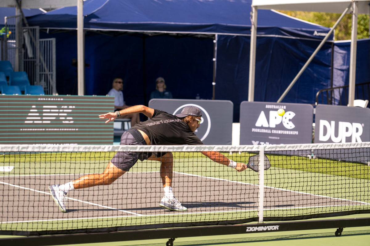 Player stretching for a ball at a Dominator net during the Australian Pickleball Championships