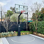 Dominator 54 inch adjustable basketball hoop in black installed on a backyard court
