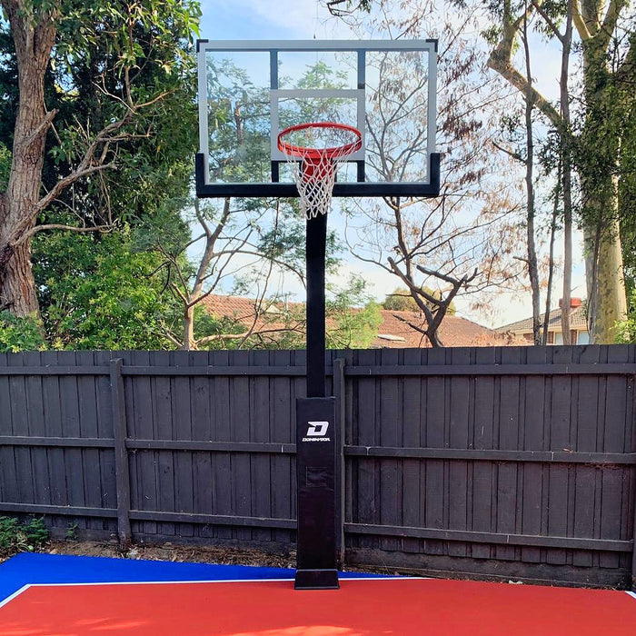 Dominator 60 inch adjustable basketball hoop in black installed on a backyard court