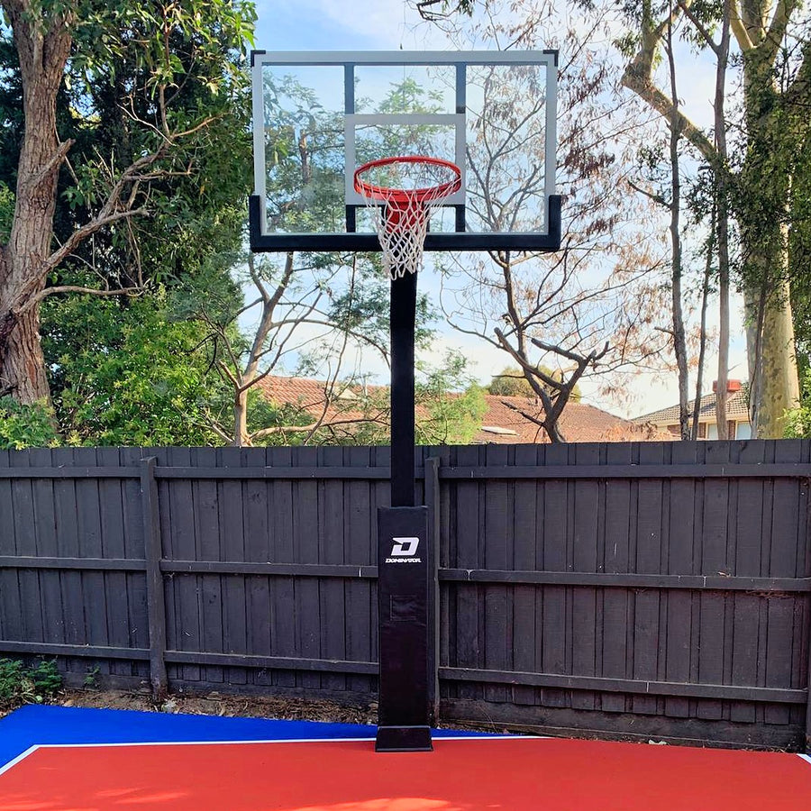 Dominator hoop with pole padding installed on a backyard court