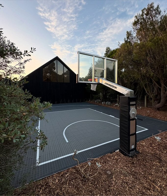 Dominator aluminium basketball hoop beside a backyard court